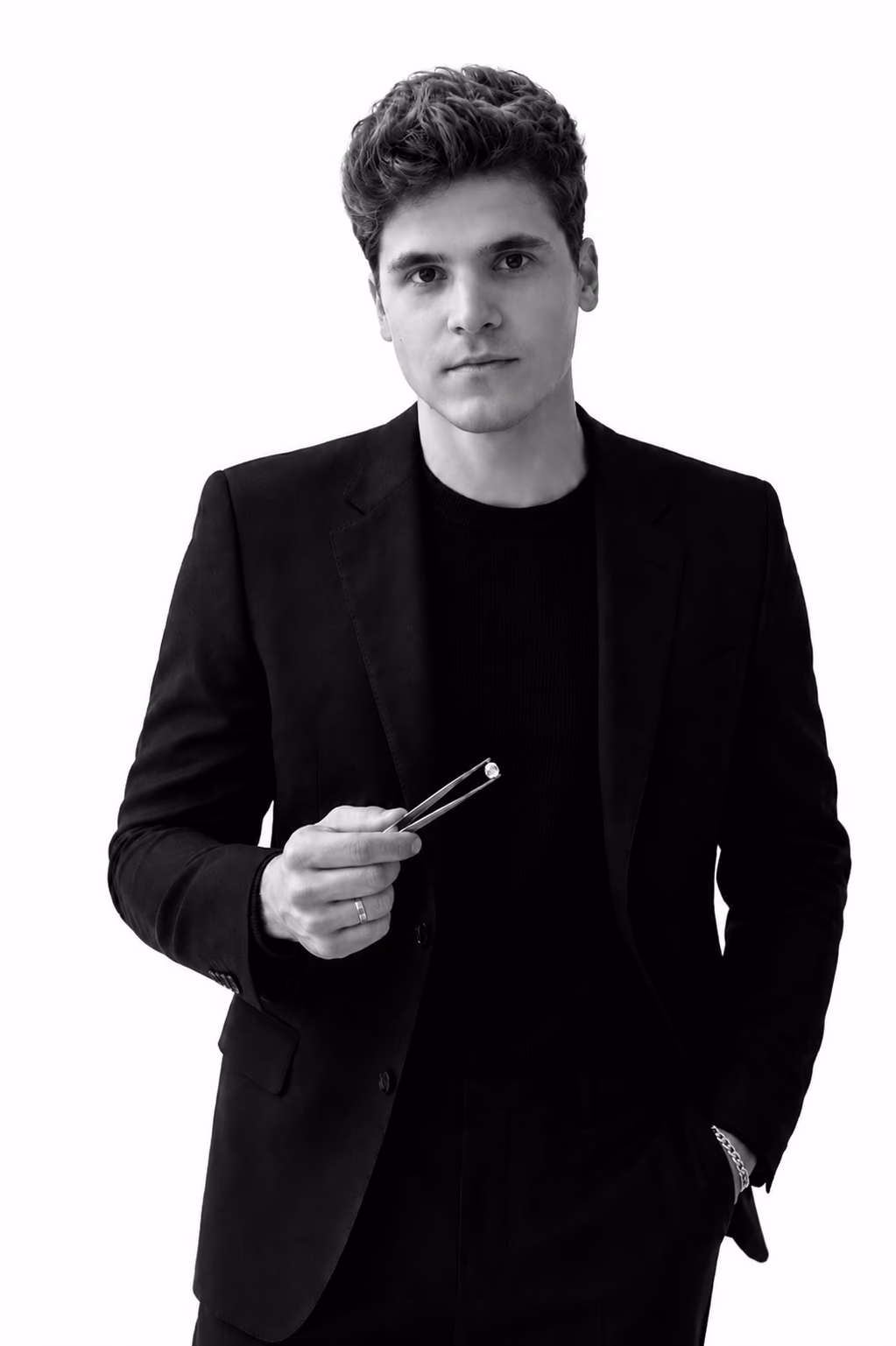 Sergey Marianovich, founder of Marianovich Gems and GIA-trained gemologist, examining a loose gemstone with jewelers' tweezers